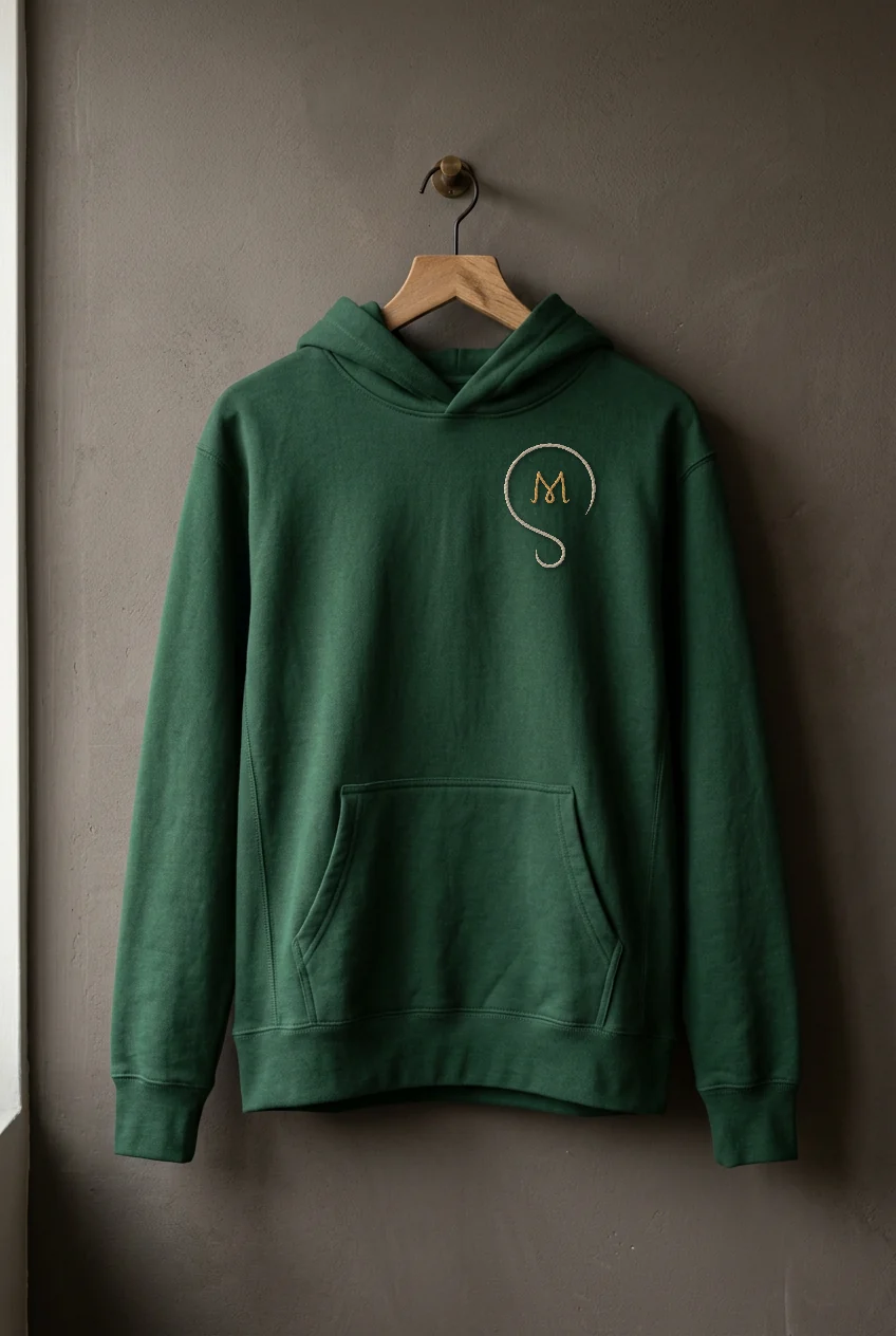 A forest green hoodie on a hanger with a small embroidered logomark on the chest.